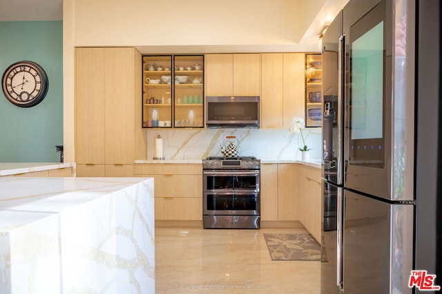 kitchen with appliances with stainless steel finishes, tasteful backsplash, and light brown cabinets