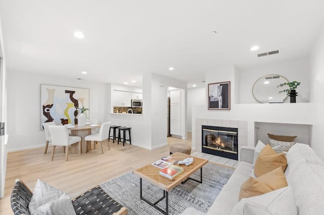 living room with a fireplace and light hardwood / wood-style flooring