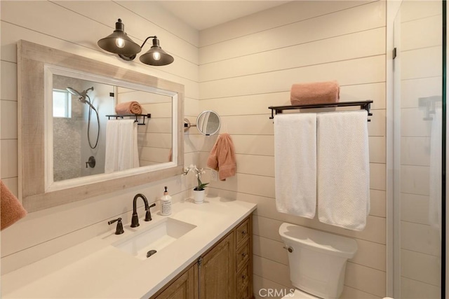 bathroom with vanity, a tile shower, and toilet