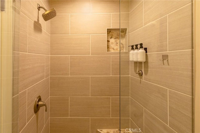 interior details featuring a tile shower