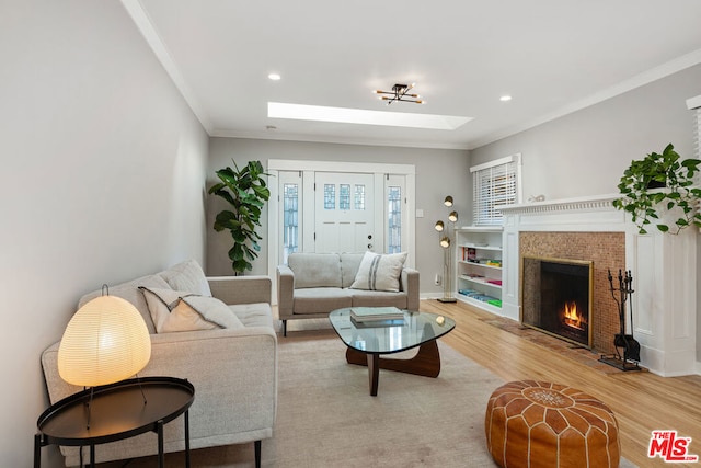 living room with hardwood / wood-style floors, a skylight, and ornamental molding