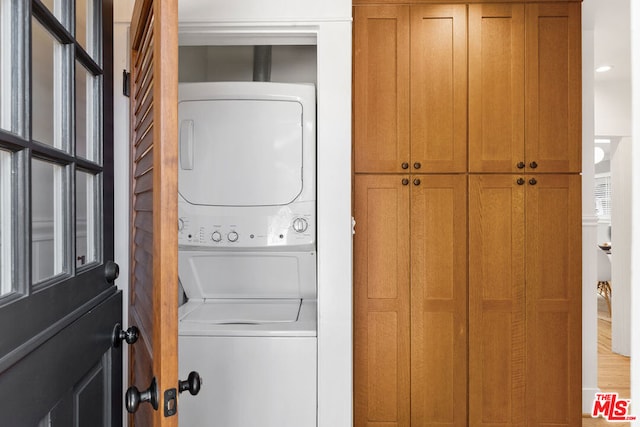 laundry room with stacked washing maching and dryer