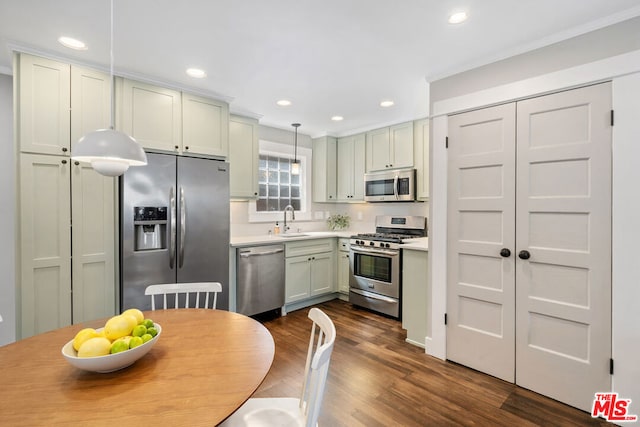 kitchen featuring sink, stainless steel appliances, dark hardwood / wood-style floors, and hanging light fixtures