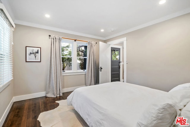 bedroom with ornamental molding and dark hardwood / wood-style flooring