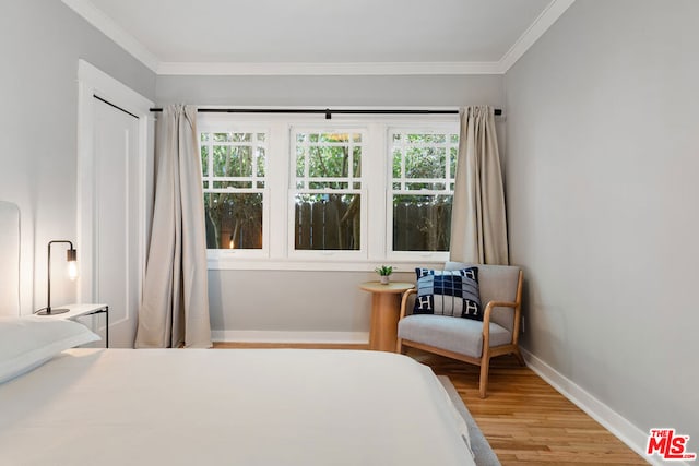 bedroom with wood-type flooring, multiple windows, and crown molding