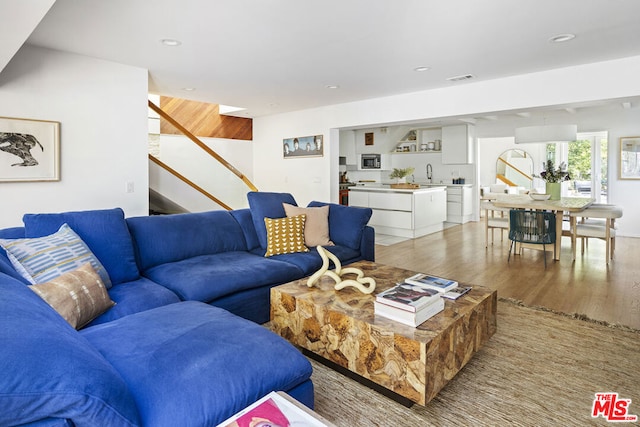 living room with sink and light wood-type flooring