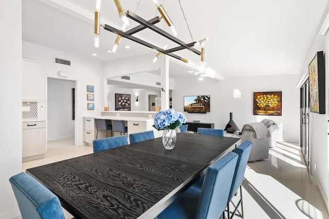 dining space with light tile patterned flooring, a notable chandelier, and lofted ceiling with beams