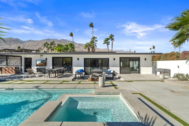 back of property featuring a mountain view and a patio area