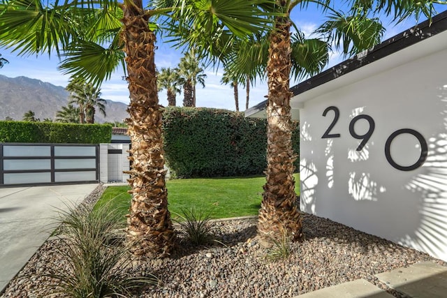 community / neighborhood sign featuring a yard and a mountain view