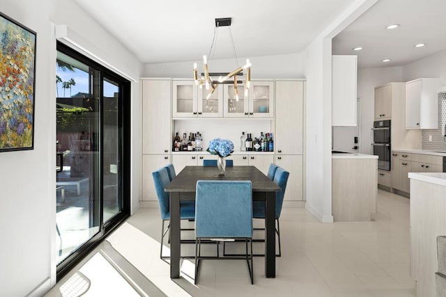 tiled dining area featuring a chandelier and vaulted ceiling