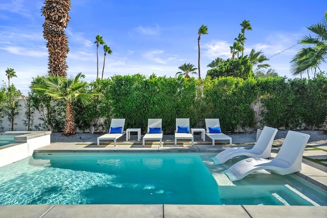 view of swimming pool with an in ground hot tub