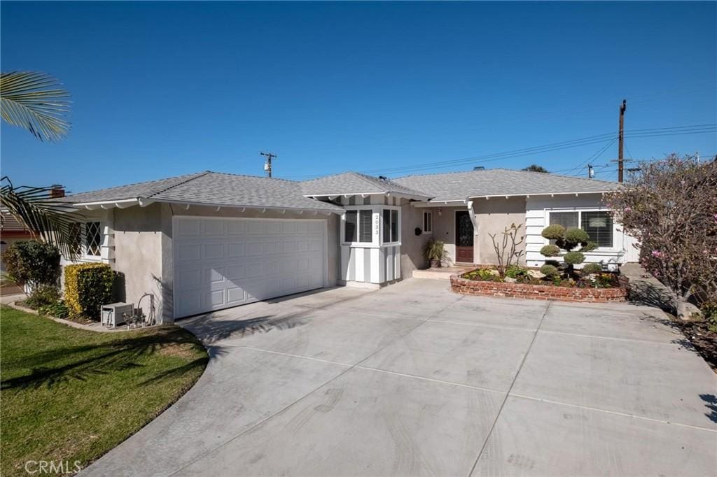 ranch-style home with a front lawn and a garage