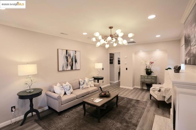 living room featuring ornamental molding, dark wood-type flooring, and an inviting chandelier