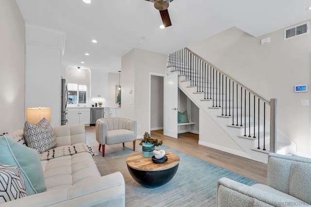 living room with light wood-type flooring and ceiling fan