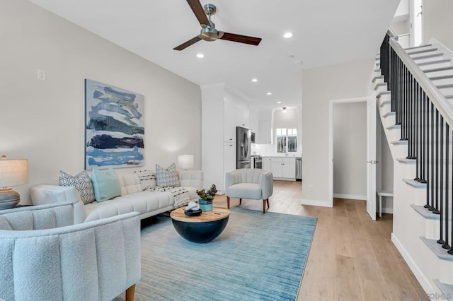 living room with ceiling fan and light hardwood / wood-style floors