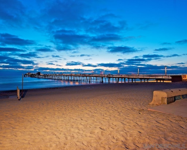 dock area with a water view and a view of the beach