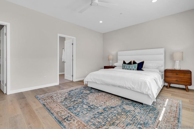 bedroom featuring hardwood / wood-style floors, ceiling fan, and ensuite bath