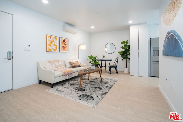 living room featuring a wall unit AC and light hardwood / wood-style floors