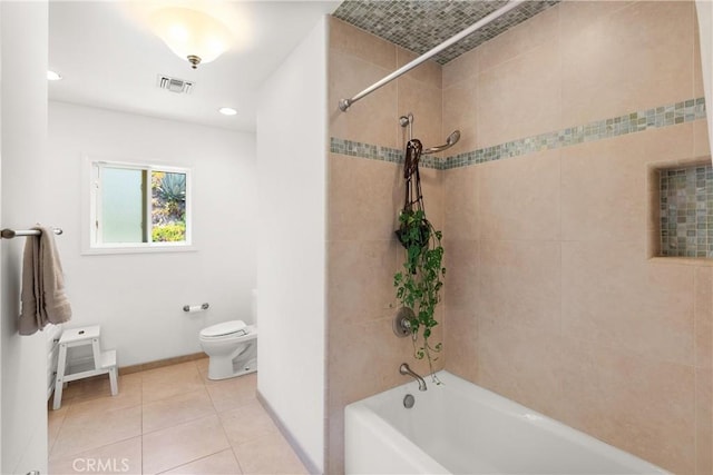 bathroom featuring toilet, tile patterned flooring, and tiled shower / bath