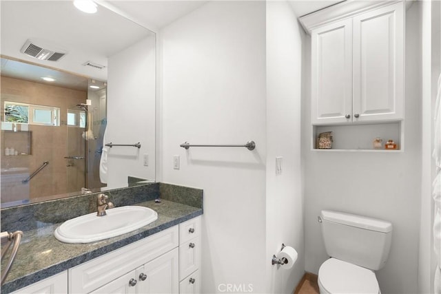 bathroom featuring toilet, walk in shower, and vanity