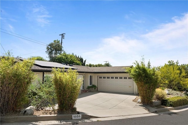 view of front of home featuring solar panels and a garage