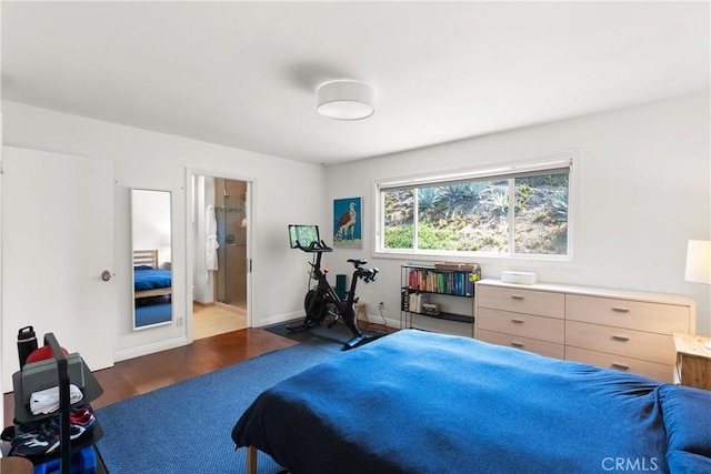 bedroom featuring ensuite bathroom and dark hardwood / wood-style floors