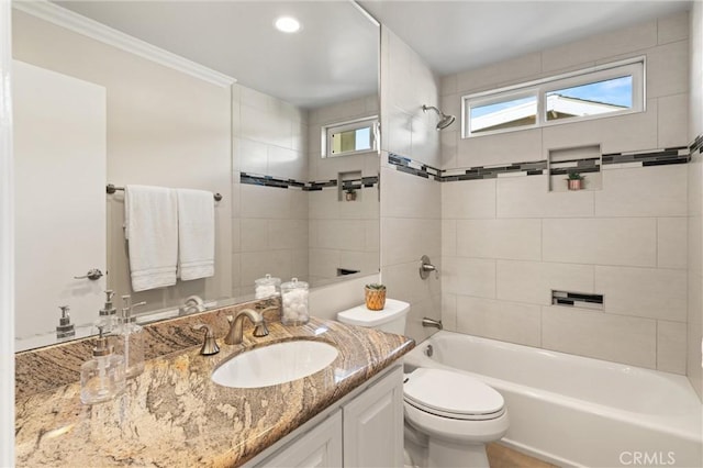 full bathroom featuring toilet, tiled shower / bath combo, ornamental molding, and vanity