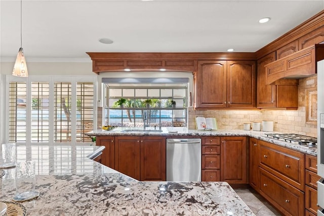 kitchen with appliances with stainless steel finishes, light stone countertops, a healthy amount of sunlight, decorative backsplash, and sink