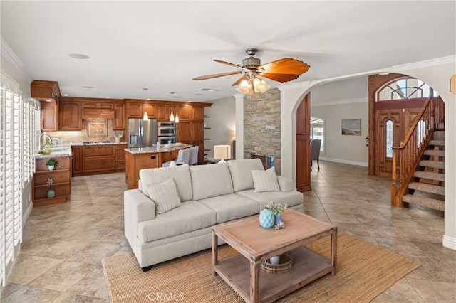 living room with ceiling fan and crown molding