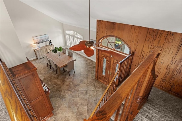 entrance foyer featuring wood walls and ceiling fan