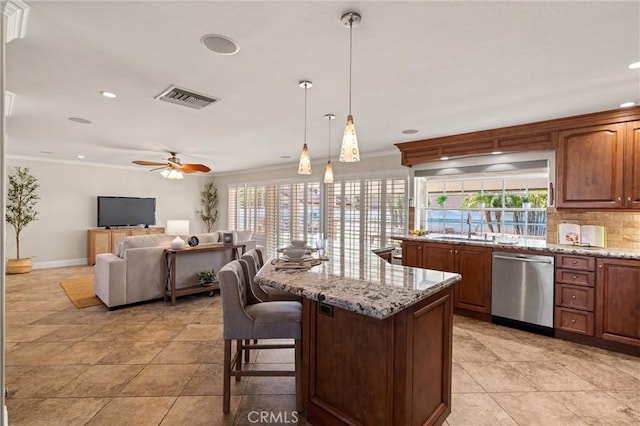 kitchen featuring ceiling fan, light stone counters, a kitchen island, decorative light fixtures, and stainless steel dishwasher