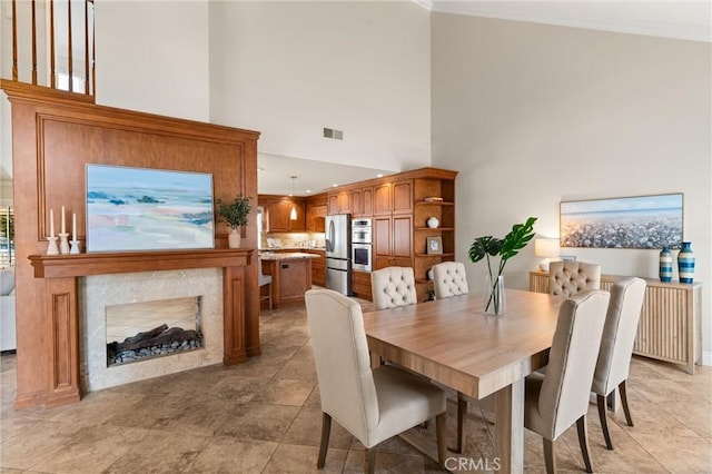 dining area featuring a towering ceiling, a fireplace, and radiator heating unit