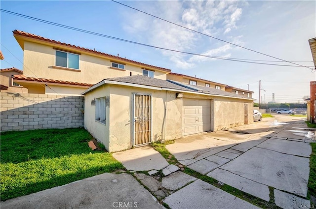 rear view of property featuring a garage and a yard