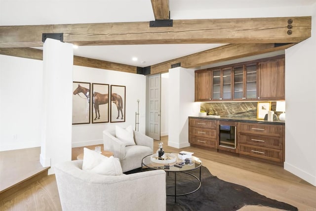 living room featuring beam ceiling and light hardwood / wood-style flooring