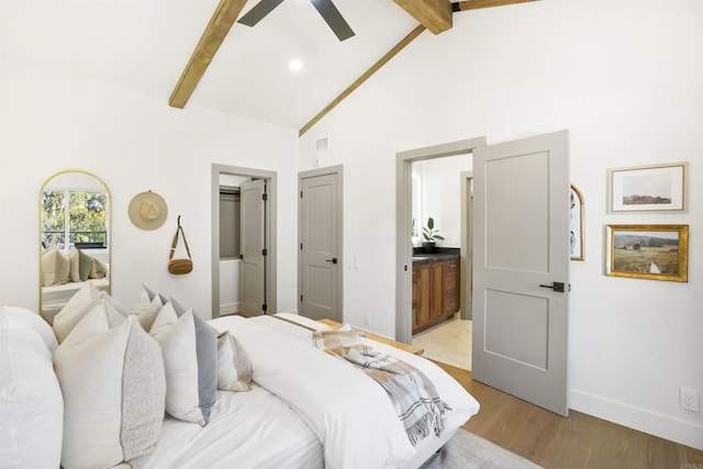 bedroom with high vaulted ceiling, beamed ceiling, ceiling fan, ensuite bath, and light hardwood / wood-style flooring