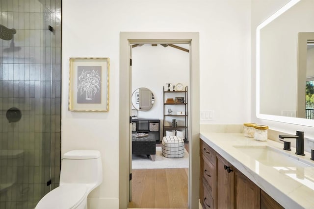 bathroom featuring hardwood / wood-style flooring, vanity, toilet, and walk in shower