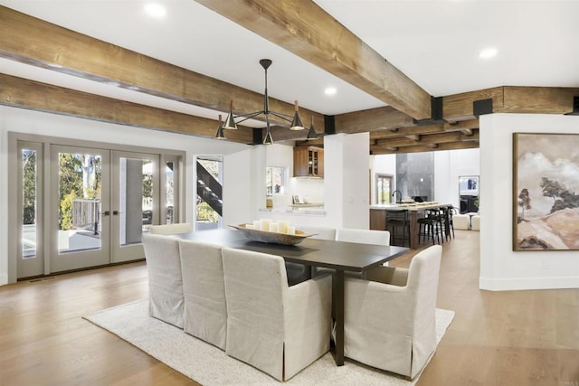 dining area with beamed ceiling, light wood-type flooring, and french doors