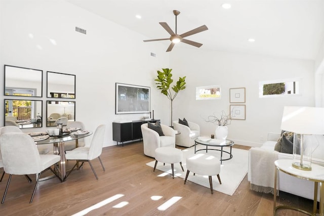 living room featuring wood-type flooring, high vaulted ceiling, and ceiling fan