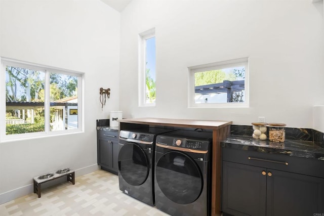 laundry area with washer and dryer and cabinets