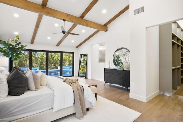 bedroom with beamed ceiling, high vaulted ceiling, and light hardwood / wood-style flooring