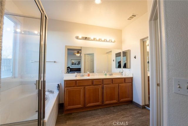 bathroom featuring vanity, shower with separate bathtub, a healthy amount of sunlight, and hardwood / wood-style flooring