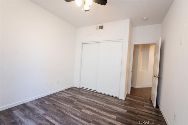 unfurnished bedroom with ceiling fan, dark hardwood / wood-style floors, and a closet