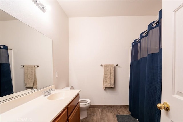 bathroom featuring wood-type flooring, toilet, vanity, and a shower with shower curtain