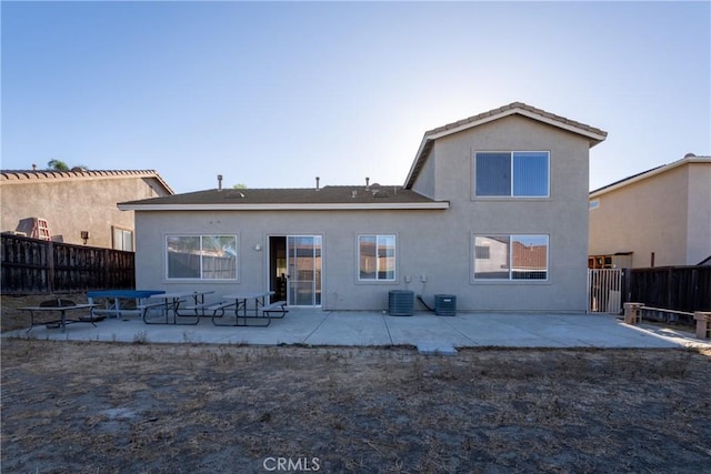 rear view of house featuring cooling unit and a patio