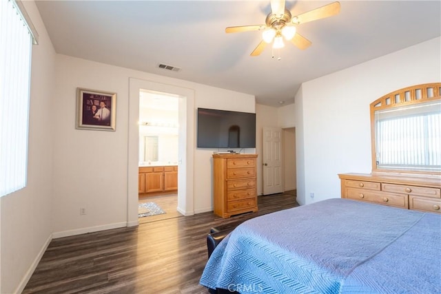 bedroom featuring ceiling fan, ensuite bath, dark wood-type flooring, and multiple windows