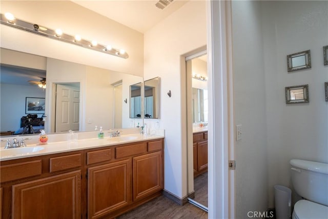 bathroom featuring toilet, vanity, ceiling fan, and hardwood / wood-style floors