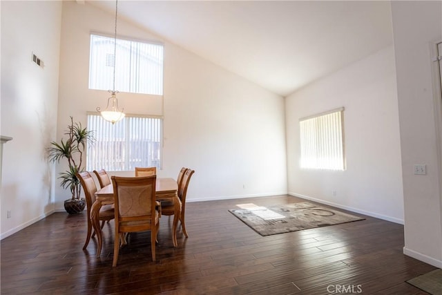 dining area with high vaulted ceiling and dark hardwood / wood-style flooring