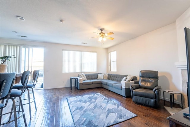 living room featuring ceiling fan and dark hardwood / wood-style flooring