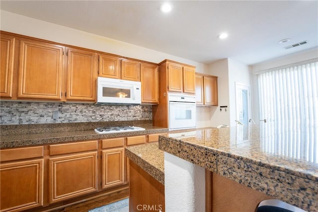 kitchen with backsplash and white appliances