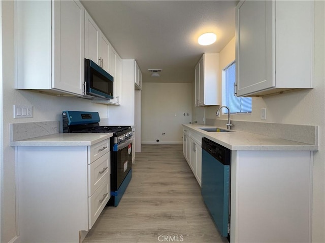 kitchen with dishwashing machine, light wood-type flooring, white cabinets, stainless steel range with gas stovetop, and sink